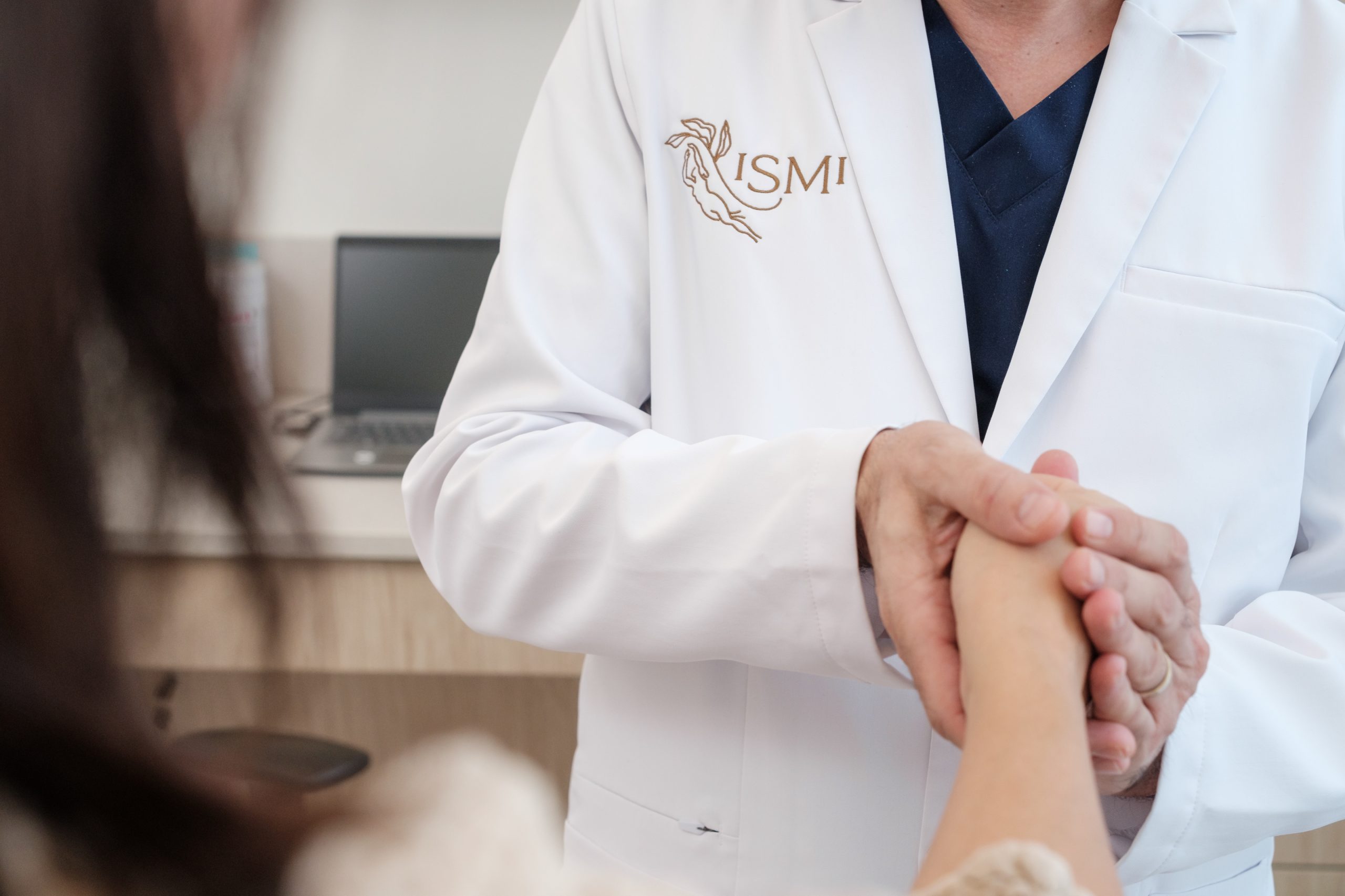 Dr Khashy Compassion Dr. Khashy warmly holding a patient’s hand during a consultation at ISMI Montreal, symbolizing trust, care, and personal connection.